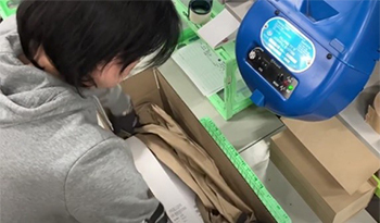 長尺製品梱包時に、FillPakを使用して箱の隙間に緩衝材を詰める作業工程①